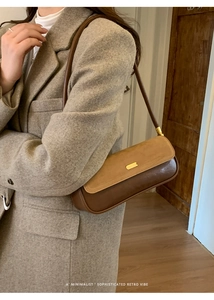 Detail of retro color-block shoulder bag with gold clasp on grey wool blazer
