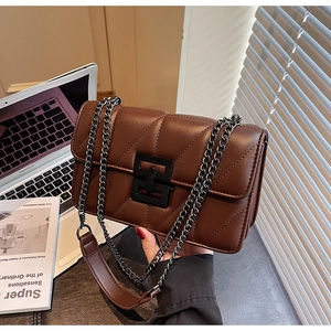 Close-up of brown PU leather shoulder bag with V-quilted stitching and matte black buckle