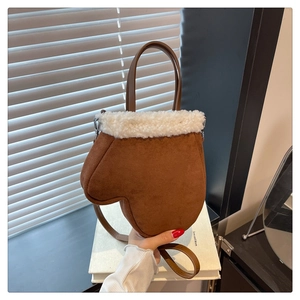 Detail of brown glove-shaped faux suede bag with white fleece trim and carrying handle