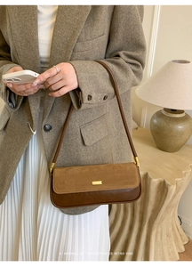 Detail of retro leopard baguette bag with gold buckle on a brown leather flap