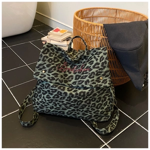 Close-up of vintage green leopard print backpack with red Bailichen embroidery and studs