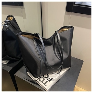 Détail du sac cabas en nylon noir montrant la texture raffinée sur un présentoir chic