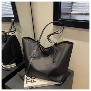 Détail d'un grand sac fourre-tout en nylon noir avec de longues bretelles et doublure or