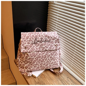 Detail of pink leopard canvas backpack featuring Bailichen embroidery and dual snap buttons