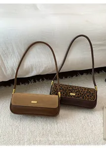 Detail showing vintage leopard print and brown leather shoulder bags with gold hardware