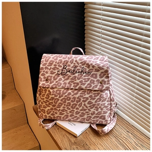 Close-up of pink leopard print canvas backpack with embroidered flip cover detail