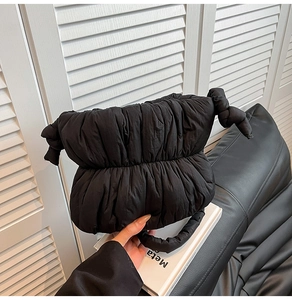 Detail of black quilted cloud bag showing soft padded texture and side knot design