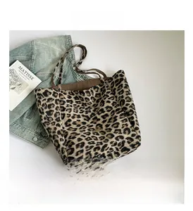 Detail view of leopard print tote bag with brown handles and Matisse art book background