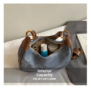 Detailed macro view showing the spacious interior and adjustable strap of denim hobo bag