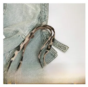 Detail of leopard print plush handle on a large canvas tote bag with woven piping