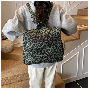 Detail view of stylish leopard print canvas backpack showing texture and pattern on model