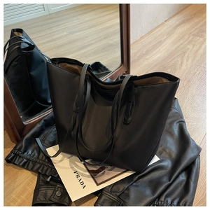 Détail d'un sac cabas noir minimaliste avec texture lisse et doublure kaki clair