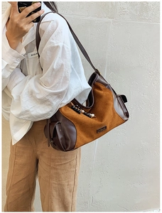 Detail of suede crossbody bag with decorative wooden beads and side pocket feature