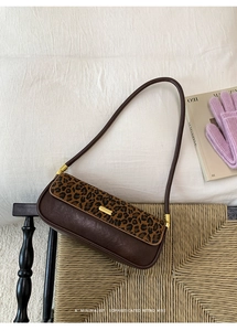 Detail shot of vintage leopard print baguette bag with brown leather and gold buckle