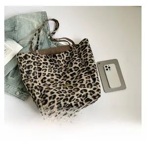 Top-down view of large zebra print tote bag next to a smartphone for size reference