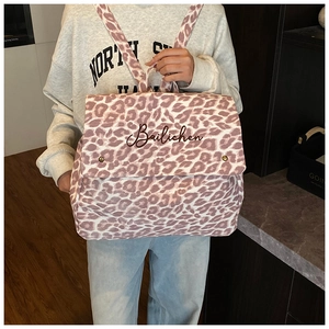 Detail of trendy pink leopard canvas backpack featuring Bailichen logo and metal buttons