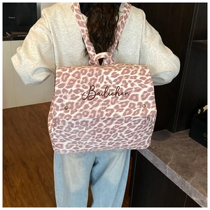 Close-up of pink leopard print canvas backpack with Bailichen embroidery detail on flap