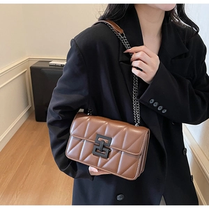 Close-up of retro brown quilted crossbody bag with stylish black metal lock and chain strap