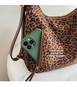 Detail showing the leopard print tote with a functional zipper pocket for phone storage