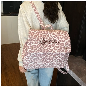 Detailed view of pink leopard print canvas backpack showing large capacity and pattern