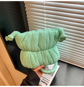 Close-up of mint green quilted cloud bag featuring unique knotted side details and soft texture