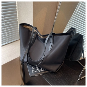 Détail d'un grand sac fourre-tout noir en nylon élégant avec des fines anses en cuir