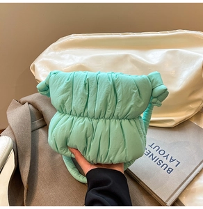 Detailed view of mint green quilted cloud bag with knotted handle and soft texture