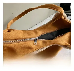 Close-up of silver zipper hardware and plush fleece lining on the brown suede tote bag
