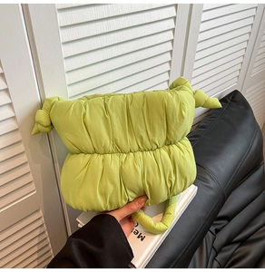 Detail view of lime green puffy cloud bag featuring knotted sides and padded handle design