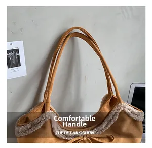 Detail of comfortable handle and plush faux fur trim on a camel suede tote bag