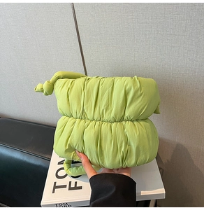 Detail of light green quilted cloud bag with knot strap and soft matte nylon texture