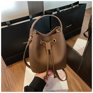 Detail view of premium dark brown lychee leather bucket bag with gold hardware buckle