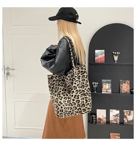 Vista laterale di una borsa tote grande con stampa leopardata indossata da una modella