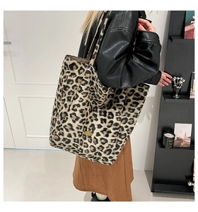 Chic leopard print canvas tote bag with wide straps shown on model in black leather jacket