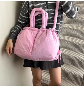 Detail of pink padded nylon tote bag with drawstring closure and thick handle design
