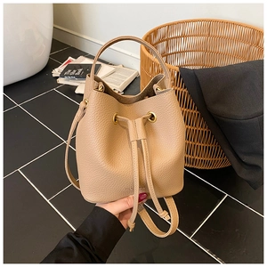 Detail of drawstring bucket bag showing lychee pattern leather and gold metal eyelets