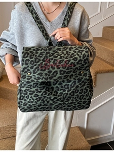 Green leopard print canvas backpack with red embroidery on a vintage casual rucksack