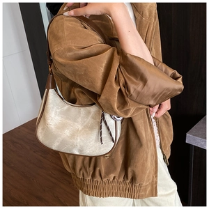Detail shot of vintage cream hobo bag with cracked texture and brown leather trim detailing