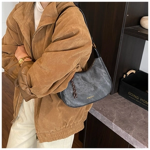 Detailed view of grey distressed moon bag with golden lettering and woven cord zipper pull