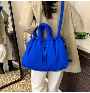 Detail of Klein blue padded quilted tote bag with drawstring closure and shoulder straps