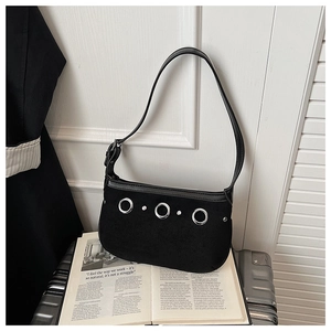 Detail of black suede shoulder bag with large silver metal rings on luxury luggage