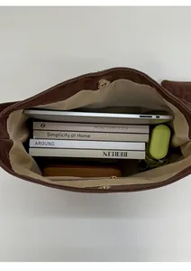 Top view of large brown tote bag showing spacious interior with books and a laptop