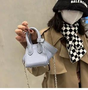 Detailed macro view of light blue lychee pattern leather bucket bag with silver chain