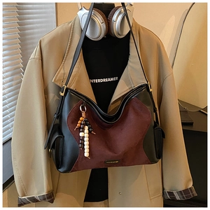 Detail of suede patchwork tote bag with bead tassel and metal ring strap buckle