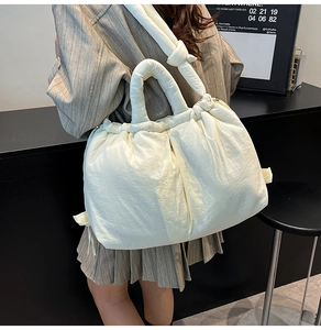Detailed view of the off-white quilted puffer tote bag on shoulder for daily casual styling