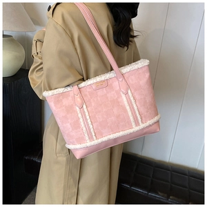 Detail of pink tote bag with white plush fur trim and petal textures on a model's shoulder