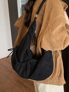 Retro black pleated hobo bag in brushed canvas material worn by a model in fall style