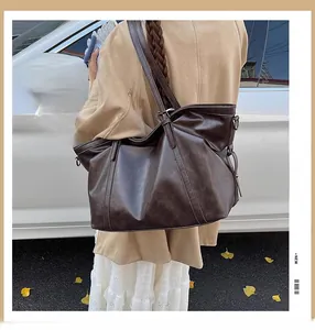 Vue détaillée du grand sac cabas marron en cuir vintage porté par un mannequin