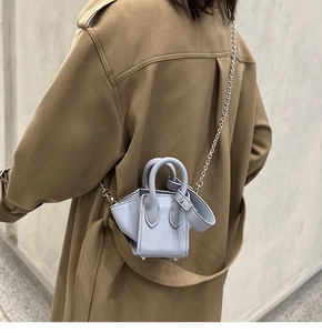 Close-up of light blue lychee pattern leather bucket bag with silver chain strap and top handle