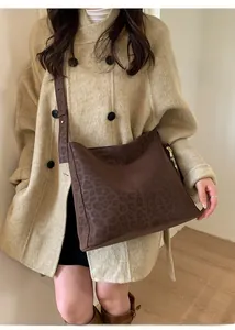 Detail view of brown leopard print crossbody bag featuring matte texture and adjustable strap